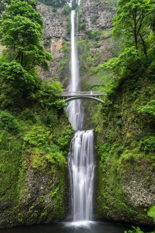 Puente de hormigón gris y cascadas durante el día